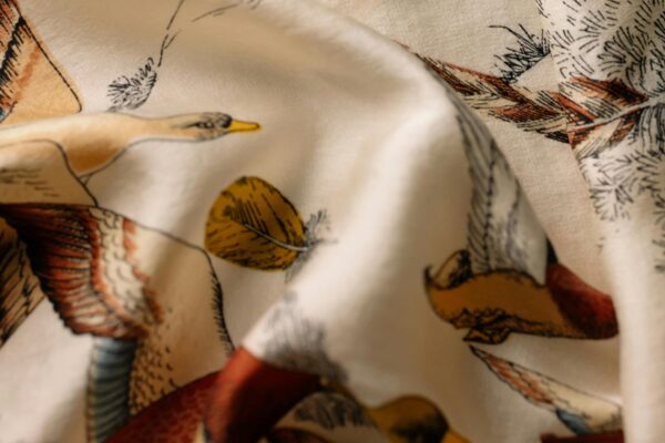 Detailed bird illustrations on draped fabric, showcasing vintage art style.
